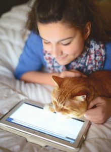 Cat and girl looking at tablet